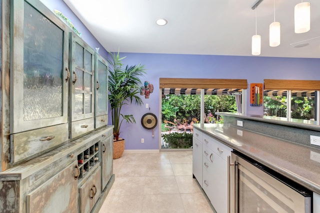110 Dolphin Rd, Ocean Ridge, FL 33435 - kitchen featuring beverage cooler, decorative light fixtures, white cabinetry, light tile patterned floors, and baseboards