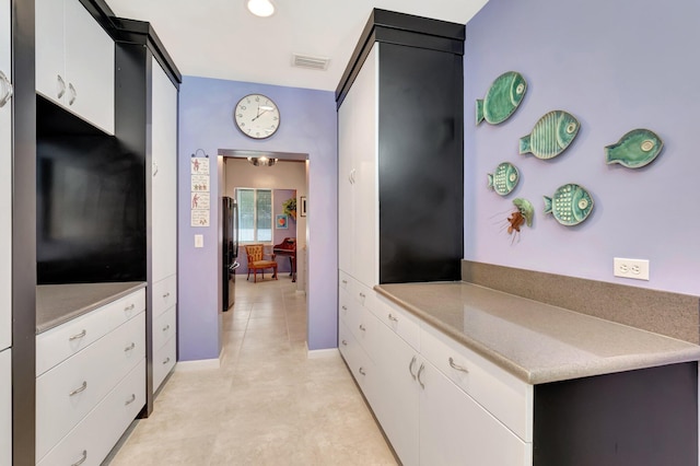 110 Dolphin Rd, Ocean Ridge, FL 33435 - kitchen featuring white cabinetry, freestanding refrigerator, and light countertops