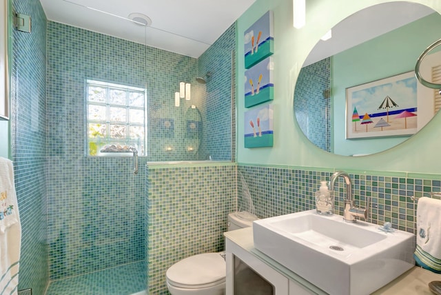 110 Dolphin Rd, Ocean Ridge, FL 33435 - bathroom with tile walls, a shower stall, toilet, vanity, and a wainscoted wall