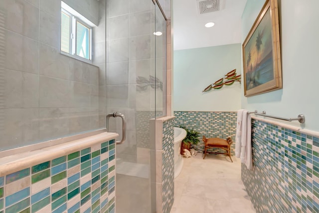 110 Dolphin Rd, Ocean Ridge, FL 33435 - bathroom featuring tile walls, a stall shower, a freestanding bath, and wainscoting