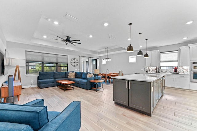 living area with a tray ceiling, wood tiled floor, and a wealth of natural light