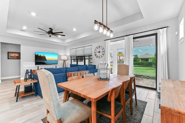dining room featuring a raised ceiling, light wood-type flooring, baseboards, ceiling fan, and recessed lighting