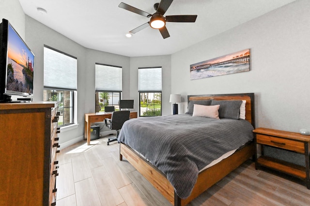 bedroom featuring baseboards, light wood-type flooring, and ceiling fan