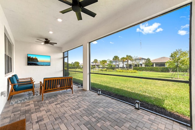 sunroom / solarium featuring ceiling fan