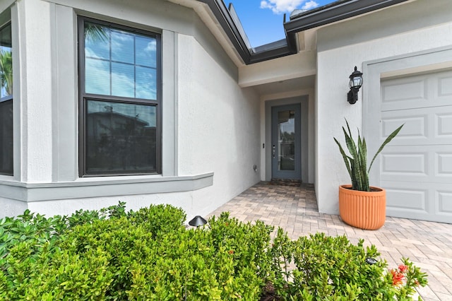 property entrance featuring stucco siding and an attached garage