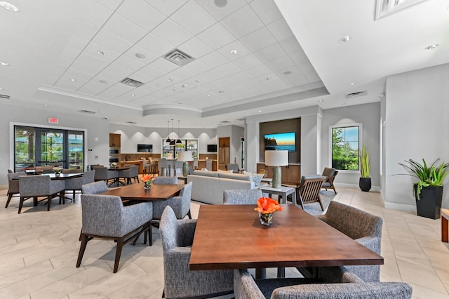 dining area with light tile patterned floors, a tray ceiling, baseboards, and visible vents