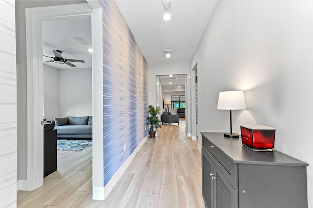 hall featuring light wood finished floors and baseboards