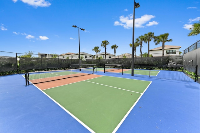 view of tennis court with fence and community basketball court