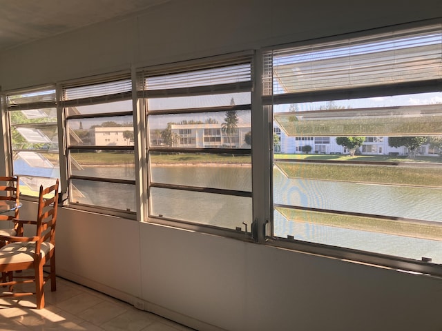 sunroom / solarium with a water view and a healthy amount of sunlight