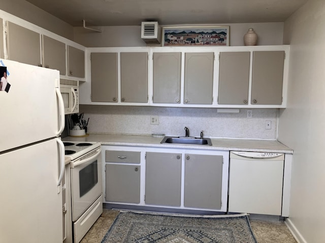 kitchen featuring light countertops, a sink, and white appliances