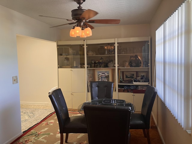 dining room featuring a textured ceiling, baseboards, and ceiling fan
