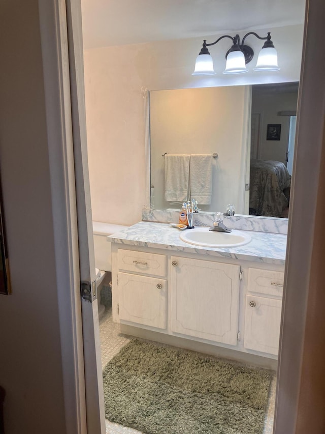 bathroom featuring toilet, vanity, and ensuite bath