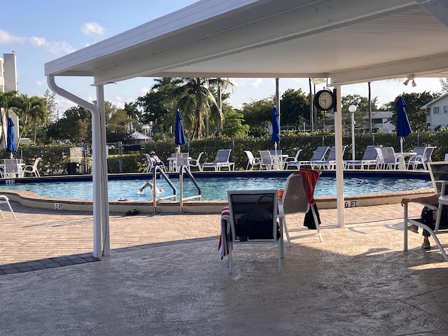 pool featuring fence and a patio area
