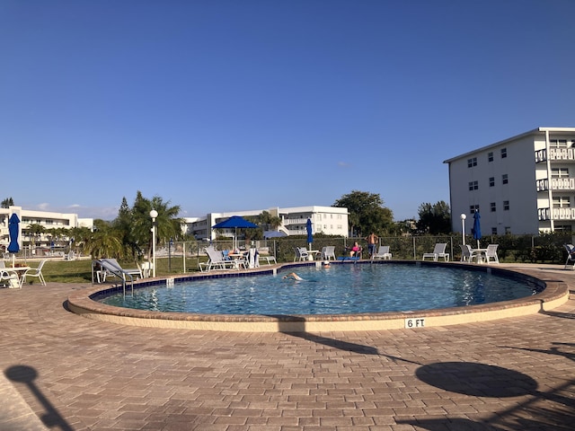 community pool featuring fence and a patio area
