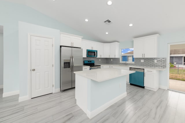 kitchen with visible vents, light countertops, lofted ceiling, appliances with stainless steel finishes, and a sink