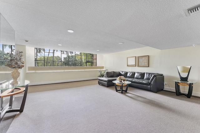 carpeted living area featuring baseboards, visible vents, and a textured ceiling