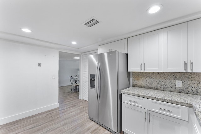 kitchen featuring white cabinets, stainless steel fridge with ice dispenser, visible vents, and light wood finished floors