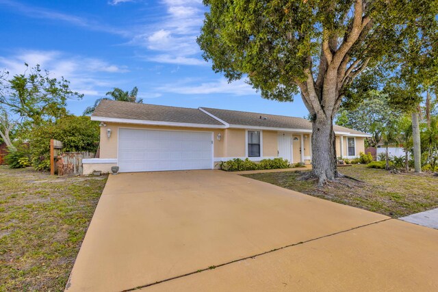 ranch-style house with a garage, a front lawn, driveway, and stucco siding