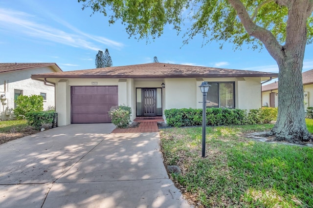 ranch-style home with stucco siding, an attached garage, and concrete driveway