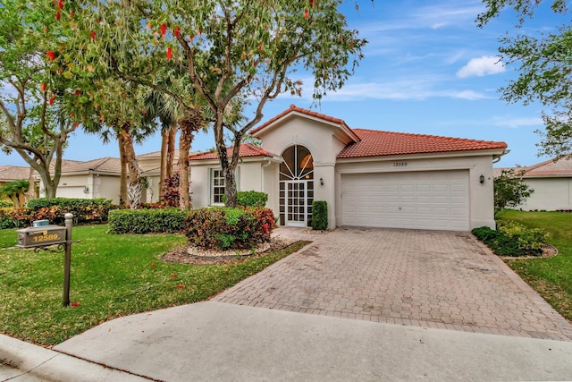 12589 Via Ravenna, Boynton Beach, FL 33436 - view of front facade with a tiled roof, a front yard, stucco siding, decorative driveway, and a garage