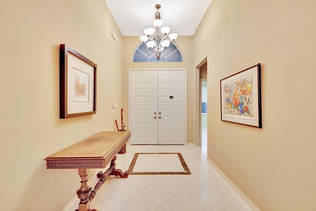 12589 Via Ravenna, Boynton Beach, FL 33436 - entryway with light tile patterned floors, baseboards, and an inviting chandelier