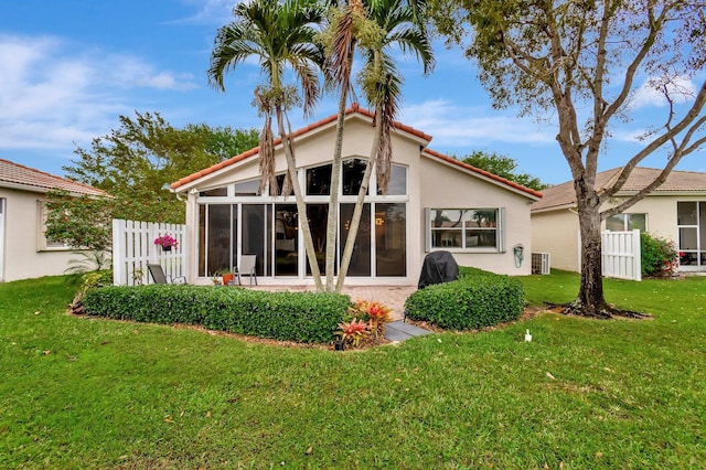 12589 Via Ravenna, Boynton Beach, FL 33436 - back of house featuring fence, a yard, a sunroom, stucco siding, and a tile roof