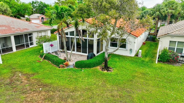 12589 Via Ravenna, Boynton Beach, FL 33436 - back of house featuring a tiled roof, a yard, a sunroom, and stucco siding