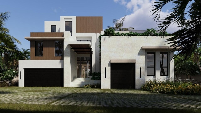 view of front facade with stucco siding and a garage
