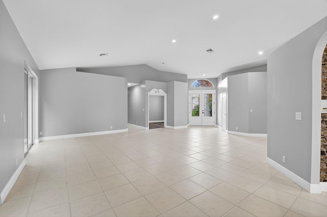 9025 Long Lake Palm Dr, Boca Raton, FL 33496 - unfurnished living room with lofted ceiling, light tile patterned flooring, arched walkways, recessed lighting, and baseboards