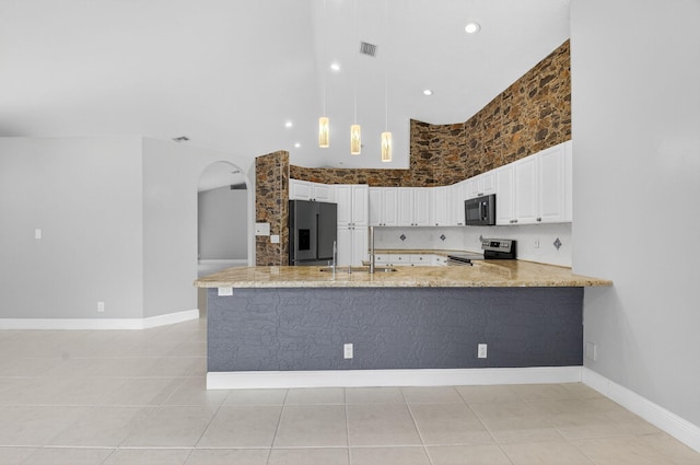 9025 Long Lake Palm Dr, Boca Raton, FL 33496 - kitchen with stainless steel appliances, arched walkways, a sink, a peninsula, and white cabinetry