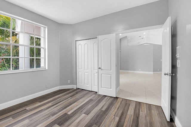 9025 Long Lake Palm Dr, Boca Raton, FL 33496 - unfurnished bedroom featuring wood finished floors, baseboards, and a closet