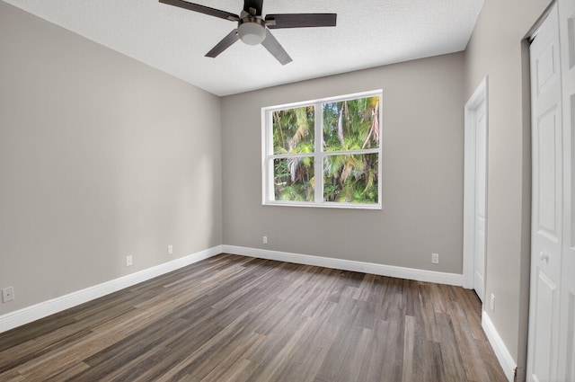 9025 Long Lake Palm Dr, Boca Raton, FL 33496 - unfurnished bedroom with dark wood-style floors, baseboards, ceiling fan, and a textured ceiling