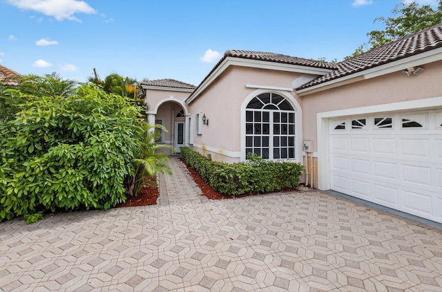 9025 Long Lake Palm Dr, Boca Raton, FL 33496 - mediterranean / spanish house with stucco siding, a tile roof, a garage, and asphalt driveway