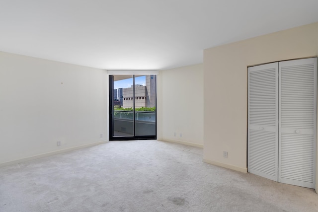 529 S Flagler Dr Unit 6E, West Palm Beach, FL 33401 - unfurnished bedroom with access to outside, carpet, baseboards, a wall of windows, and a closet