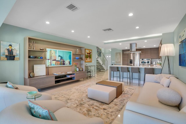 living area with visible vents, recessed lighting, and stairway