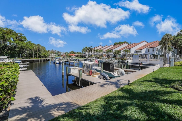dock area featuring a residential view, a water view, and a lawn