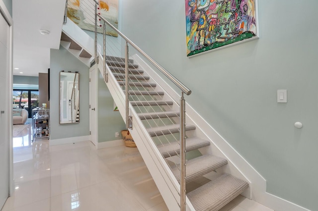 stairs featuring tile patterned floors and baseboards