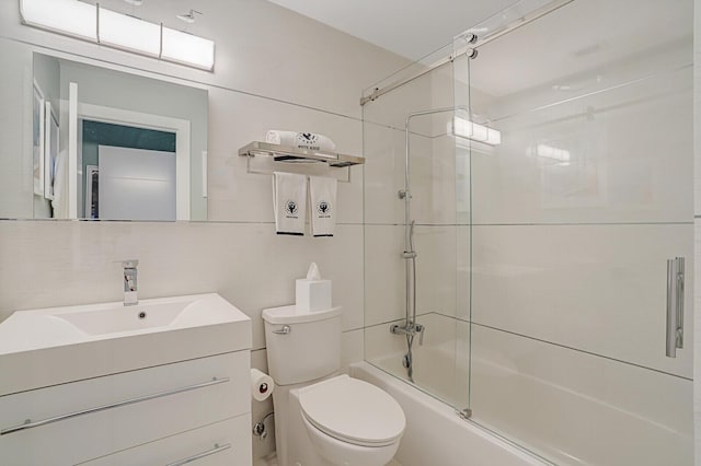 full bathroom with toilet, tasteful backsplash, combined bath / shower with glass door, tile walls, and vanity