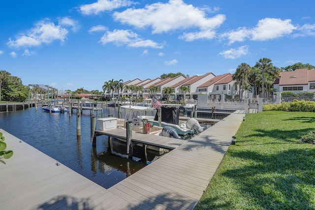 view of dock with a residential view, a yard, and a water view