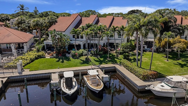 view of dock with boat lift, a lawn, and a water view