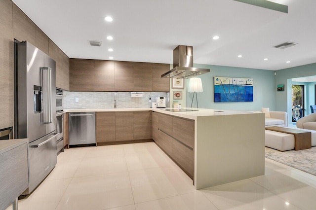 kitchen featuring visible vents, modern cabinets, range hood, stainless steel appliances, and light countertops