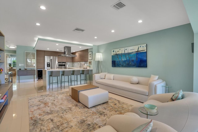 living area featuring beverage cooler, recessed lighting, and visible vents