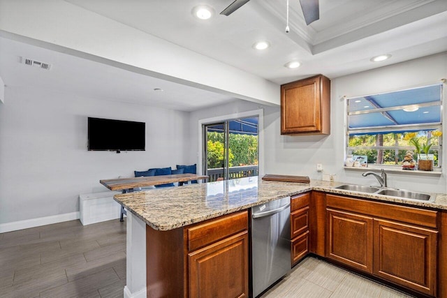 kitchen with light stone countertops, brown cabinets, a peninsula, stainless steel dishwasher, and a sink