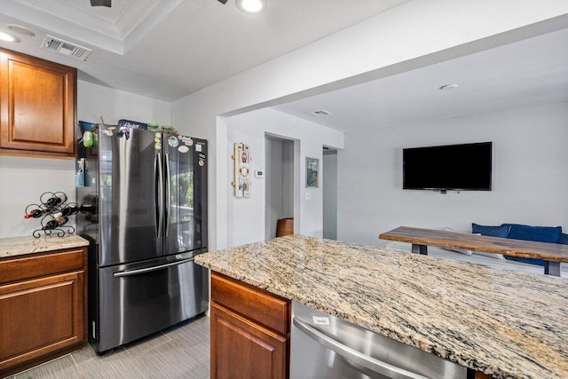 kitchen with brown cabinetry, light stone countertops, visible vents, recessed lighting, and stainless steel appliances