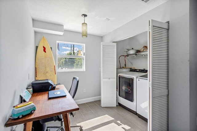 office space featuring washing machine and clothes dryer, visible vents, a textured ceiling, and baseboards