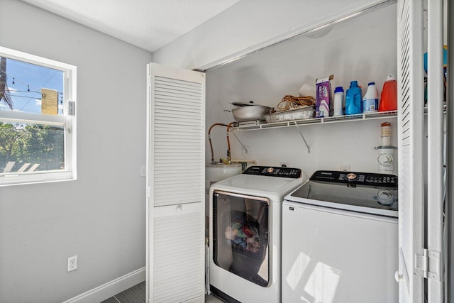 clothes washing area featuring a textured ceiling, laundry area, baseboards, and washer and clothes dryer