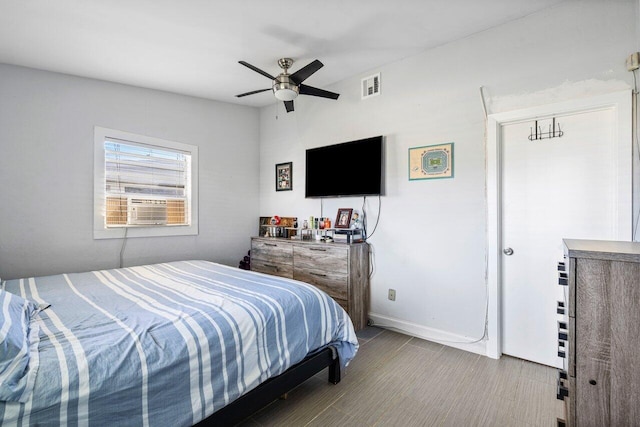 bedroom with ceiling fan, visible vents, baseboards, and cooling unit