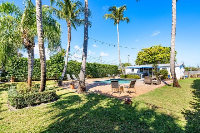 pool with a yard and a patio area