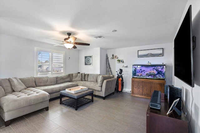 living area with visible vents, a textured ceiling, and ceiling fan