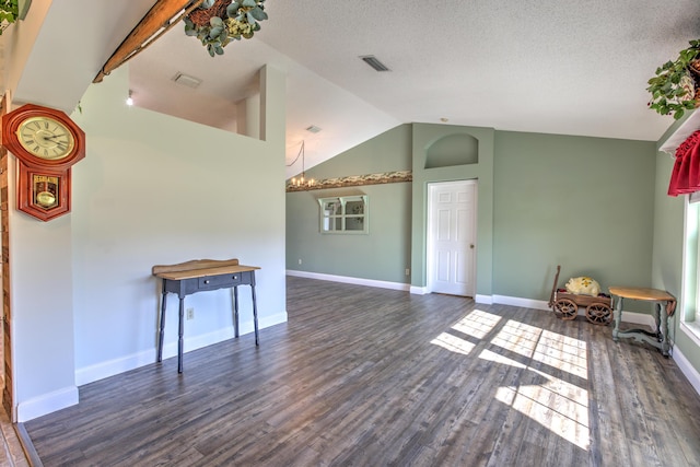 interior space with visible vents, baseboards, lofted ceiling, and wood finished floors